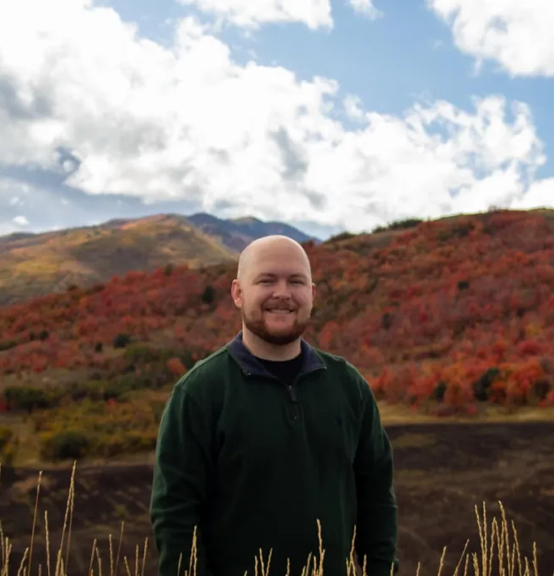 Man in green sweater with autumn hills
