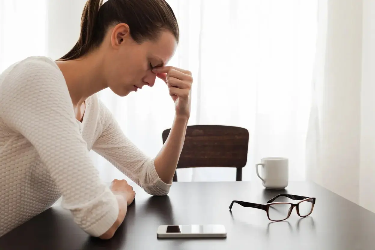 Woman resting head at table with glasses