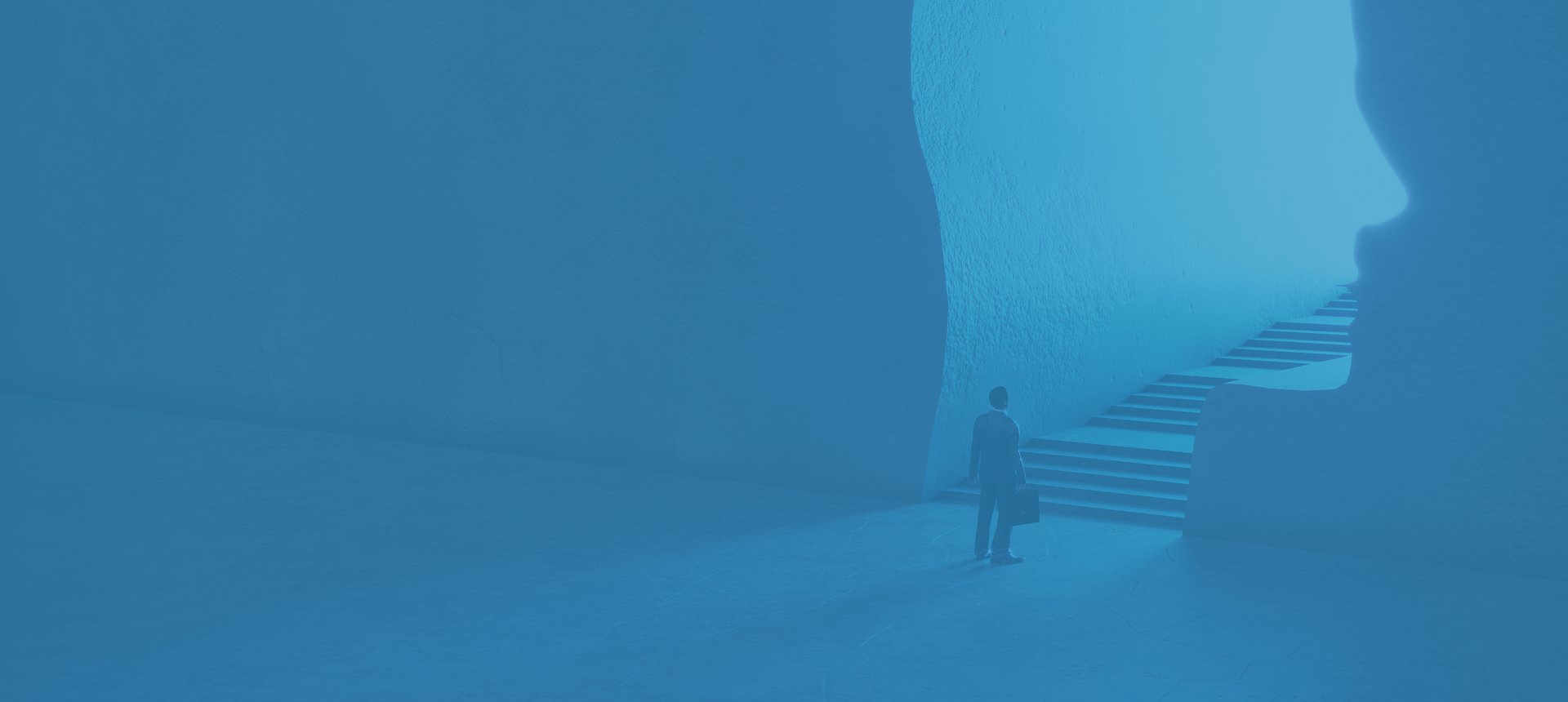 A person stands near a large, curved blue wall in a minimalist space.