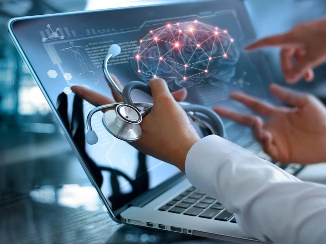 Doctor analyzing brain scan on laptop